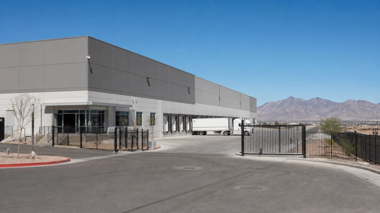 Modern warehouse and distribution center exterior with a security camera and gated entrance, representing warehouse security in Las Vegas