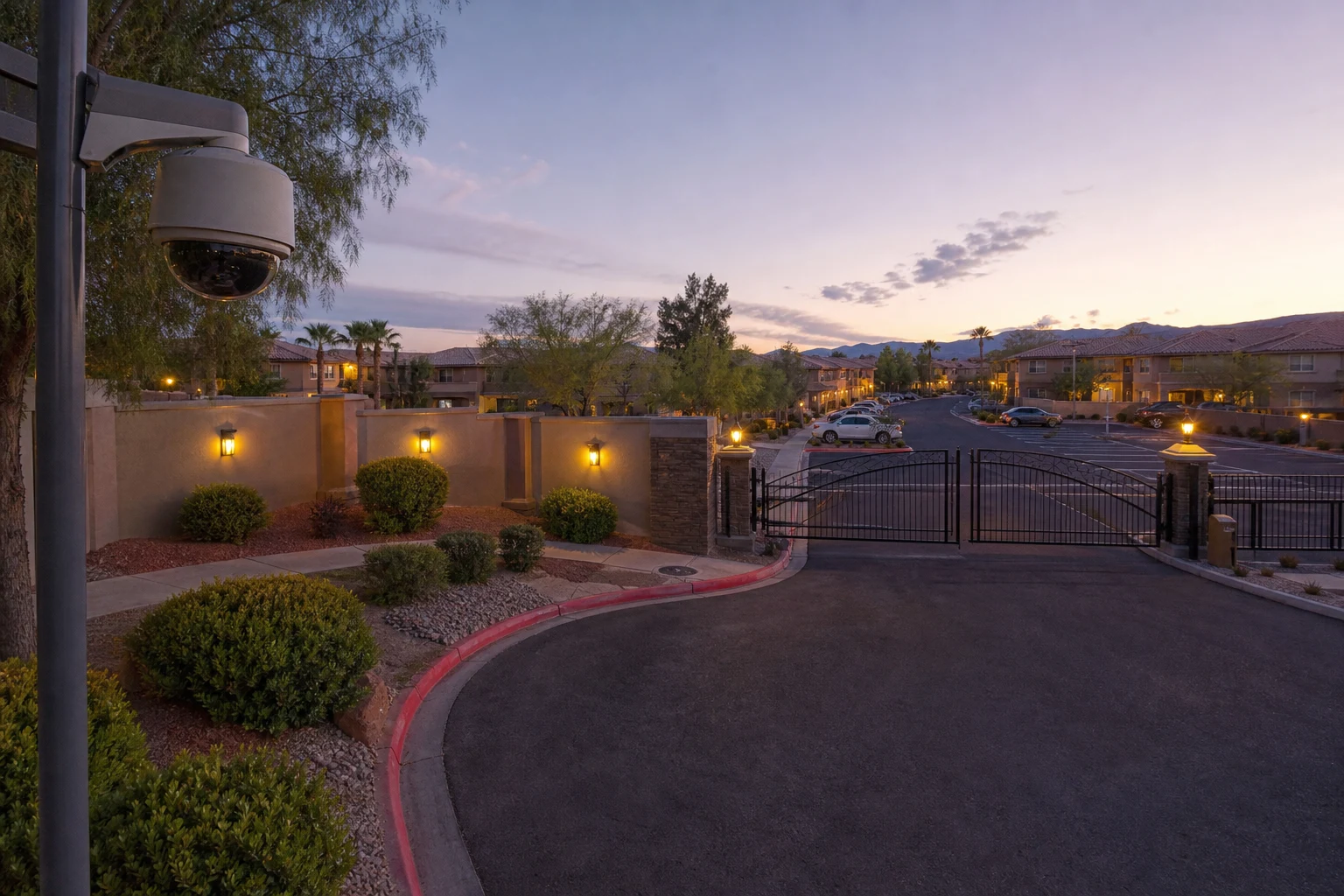 Security camera covering a gated HOA parking area and vehicle entrance in a Las Vegas community at dusk